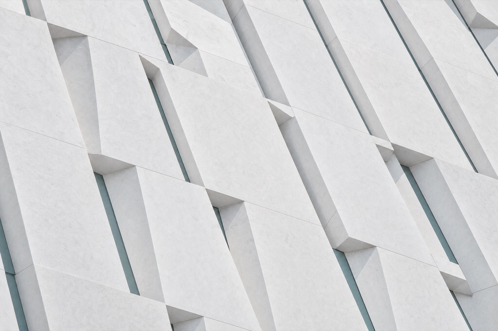 Precise white geometric stone facade with repeating structural pattern